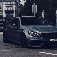 a grey car parked on the street in front of some buildings