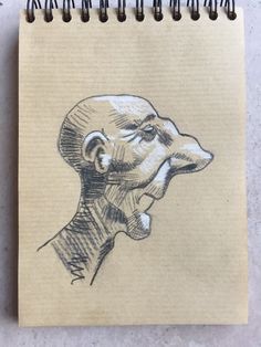 a drawing of a man's head is shown on top of a notepad