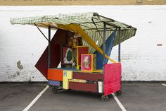 a cart that is sitting in the parking lot with some pictures on top of it