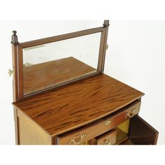 a wooden desk with a mirror on it's top and drawers below the table