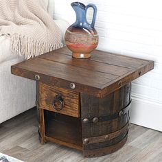 an old wooden table with a vase on top