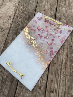 a piece of glass with gold flecks on it sitting on top of a wooden table