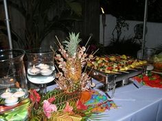 a table topped with lots of food next to two vases filled with flowers and candles