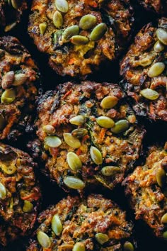 several muffins with pumpkin seeds are stacked on top of each other in a pile