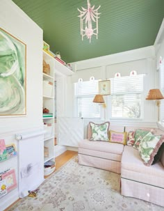 a living room filled with furniture and a chandelier hanging from the skylight