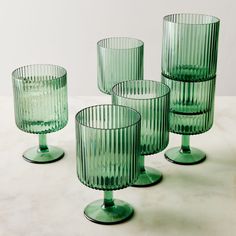 four green glass cups sitting on top of a table