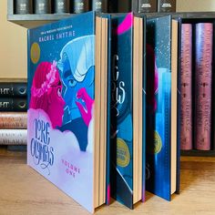 the books are lined up next to each other on the table in front of some bookshelves