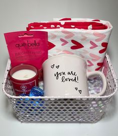 a basket filled with personal care items on top of a white table next to a cup