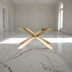 a white marble floor with a gold x design on the center and two windows in the background