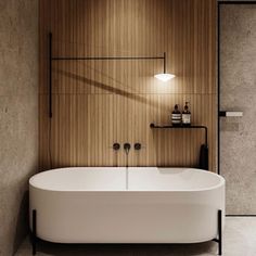 a white bath tub sitting next to a wooden wall