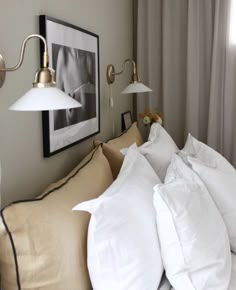 a bed with white pillows and two lamps