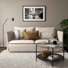 a living room filled with furniture and a round mirror on the wall over a coffee table