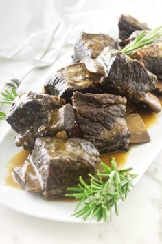 some food is sitting on a white plate and garnished with green sprigs