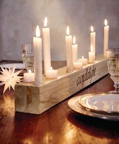 there are many lit candles in the center of this wooden box on top of a table