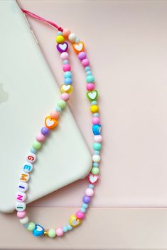 a colorful beaded necklace next to an iphone