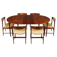 a dining table with six chairs and a round wooden table on the top, all in walnut