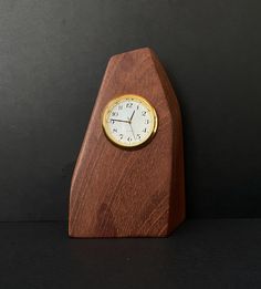 a small wooden clock sitting on top of a table