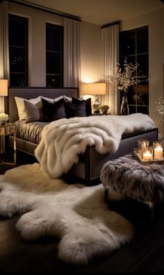 a bedroom with fur rugs on the floor and two candles in front of the bed