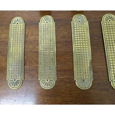 three brass door handles on a wooden surface