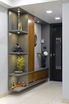 a room that has some shelves with vases and plants on them in front of a door