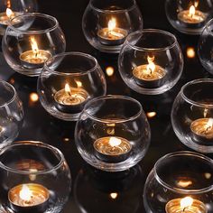 many clear glass bowls with lit candles in them