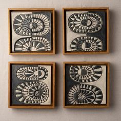 four black and white paintings in wooden frames