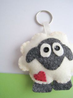 a stuffed animal keychain hanging from a hook on a green and white wall