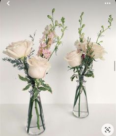 two vases with flowers in them on a table