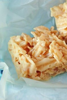 two pieces of food sitting on top of a blue paper bag with white frosting