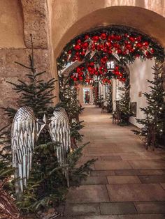 an archway decorated for christmas with angel wings and poinsettis on either side