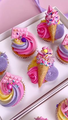 cupcakes decorated with pink, purple and yellow frosting