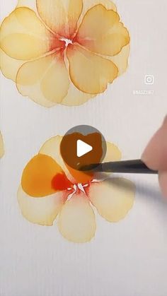 someone is painting flowers with watercolors on paper and using a brush to paint them