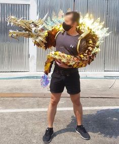 a man is standing in the parking lot with his arms wrapped around an elaborate dragon costume