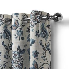 a curtain with blue flowers on it hanging from the side of a window sill