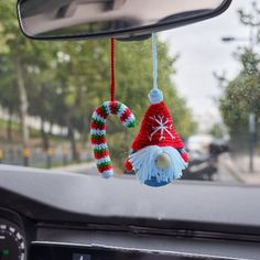 two christmas decorations hanging from the dashboard of a car