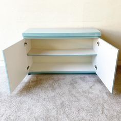 a blue and white cabinet sitting on top of a carpeted floor