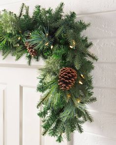 a wreath with pine cones hanging from it