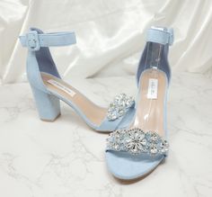 a pair of blue high heeled shoes with crystal embellishments