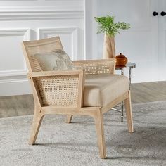 a wooden chair sitting on top of a carpeted floor next to a potted plant