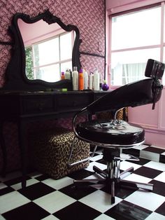 a black and white checkered floor with a chair in front of a vanity table