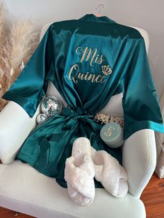 "Celebrate your special Quinceañera with our beautiful Mis Quince Satin Robe, a perfect addition to your memorable day! Crafted from high-quality soft silky satin, our Quinceañera robe ensures a luxurious and comfortable experience while getting ready for the celebration. Our robes come with inner side pockets!  Customize your robe with glitter text or mirror metallic for that extra touch of glamour! Choose from a variety of glitter or metallic options to make your Mis Quince Robe uniquely yours Emerald Green Quinceanera Surprise Dance Outfit, Emerald Green Quince Robe, Dark Teal Quinceanera Theme, Quince Green And Gold, Quince Robe Ideas, Chambelanes Outfits Quinceanera Sage Green, Mis Quince Robe, Emerald Green Enchanted Forest Quince, Quince Ideas Decoration