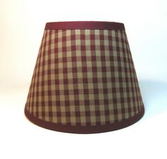 a brown and white checkered lampshade on a white background with red trim