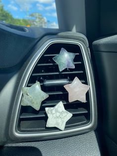 five stars are placed on the air vent in a car's dash board holder