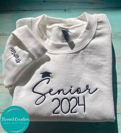 Thank you for your interest in our store. Per our shop update, orders placed now will be shipped out no earlier than 2 weeks, excluding USPS shipping time! Orders will not be delivered by Christmas. Custom Senior 2024 Embroidered Sweatshirt with Personalized Sleeve Celebrate your senior year in style with our custom embroidered sweatshirt, designed especially for the graduating class of 2024. We understand the significance of this milestone, and we've created a special keepsake that allows you to proudly display your class year and your own name on the sleeve in a unique and stylish way. Give the Gift of Graduation. Our custom embroidered sweatshirt also makes a thoughtful and personalized gift for the soon-to-be graduate in your life. It's a perfect way to show your support and pride. 👉E Senior Year Hoodie Design, Senior Family Shirts, Senior Sweater Ideas, Senior Hoodies Design Ideas 2025, Senior Merch Ideas, Senior Crewneck Ideas, Senior Hoodie Ideas, Seniors Sweatshirt, School Sweatshirts Designs