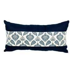 a blue and white pillow with an embroidered design on the front, sitting against a white background