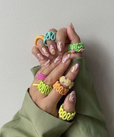 a woman's hands with painted nails and letters on them