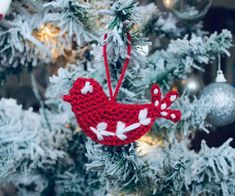 a crocheted bird ornament hanging from a christmas tree