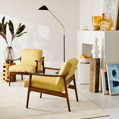 a living room with two chairs and a lamp on the floor next to a fireplace