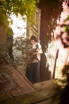 a man standing in front of a doorway holding a cat