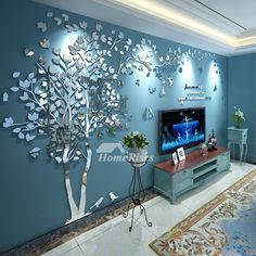 a living room with blue walls and a tree on the wall in front of it